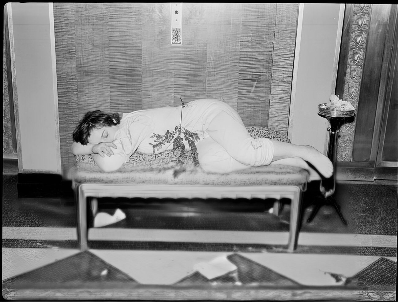 A woman sleeping on a small couch, 1951.