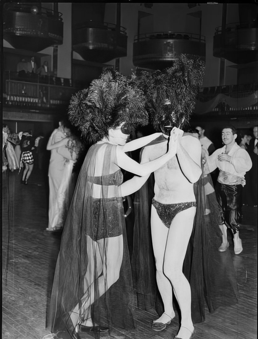 A couple with ornate headpieces dancing at the ball, 1951.