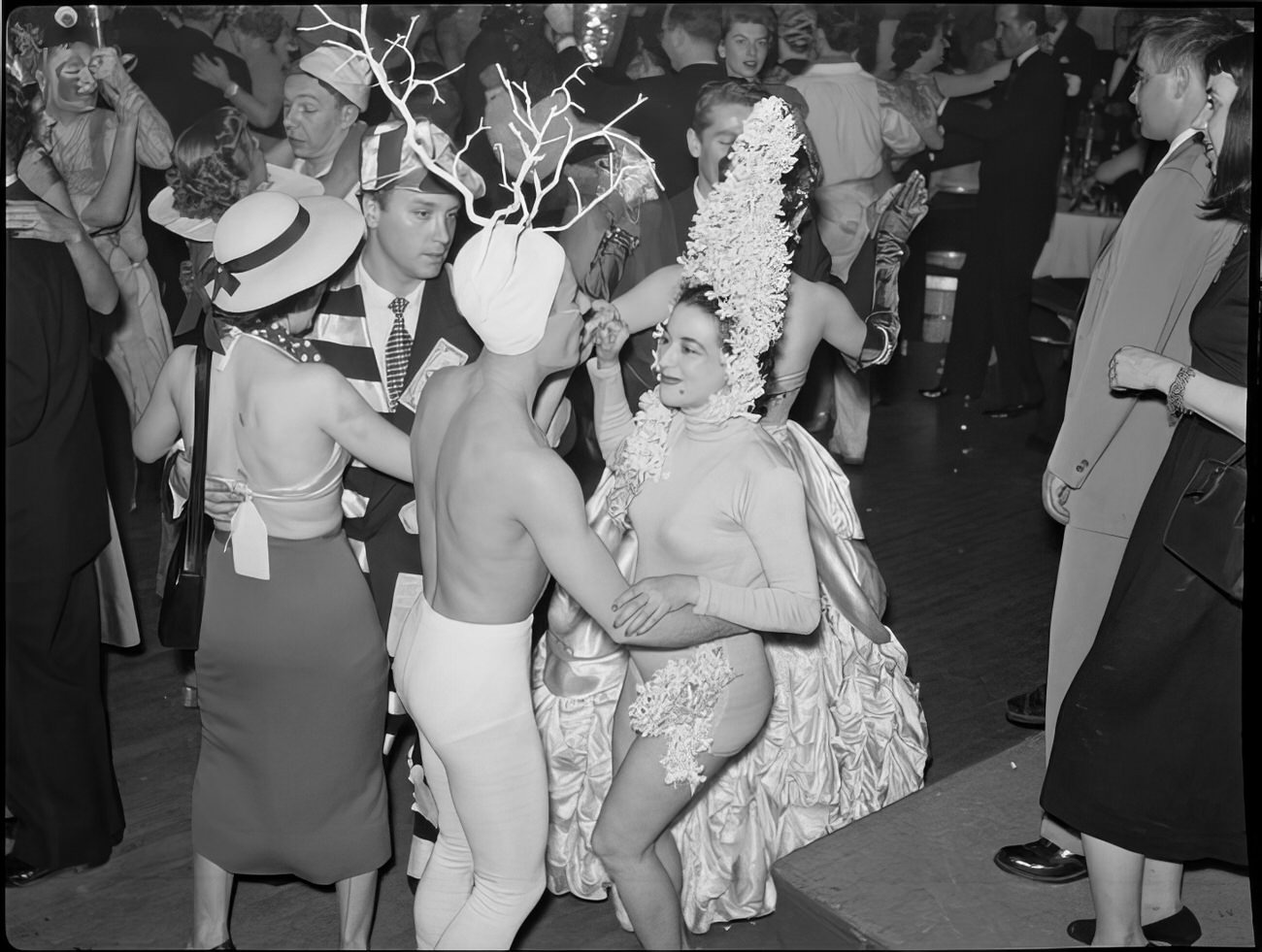 A dancing couple wearing elaborate headpieces, 1951.