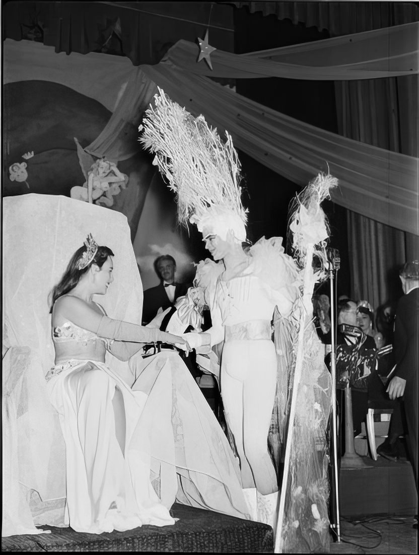 A woman giving a man a prize for best costume, 1951.