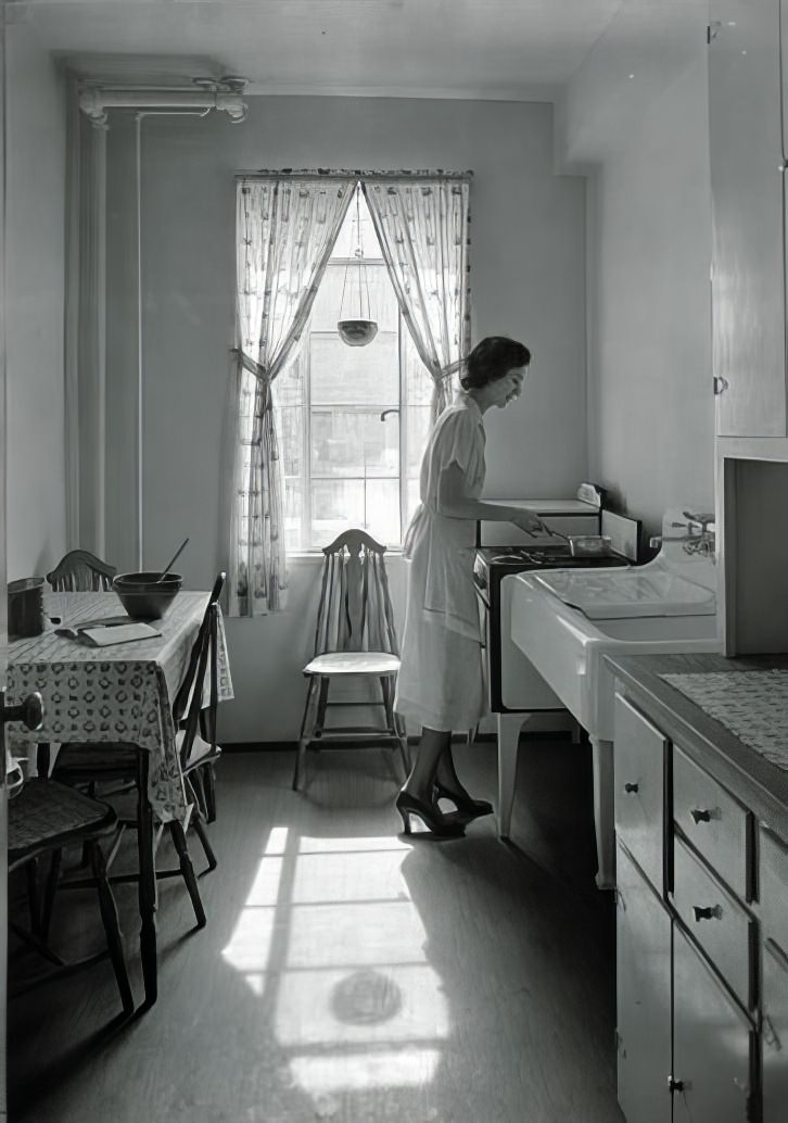 Kitchen with Mrs. Lenninger standing, 1935.