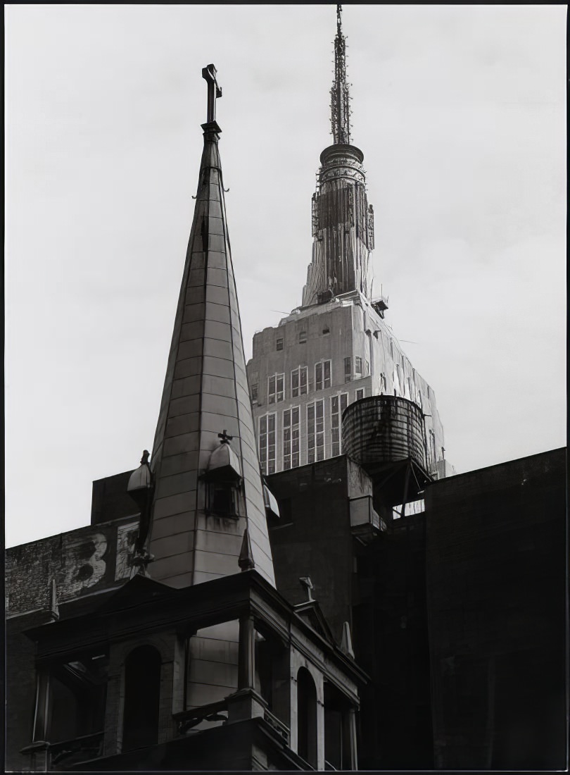 Steeple of St. Francis of Assisi Roman Catholic Church, 135 West 31st Street, with the Empire State Building, 1971