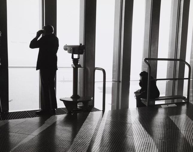 People looking out over New York Harbor from the World Trade Center's South Tower observation deck, 1974