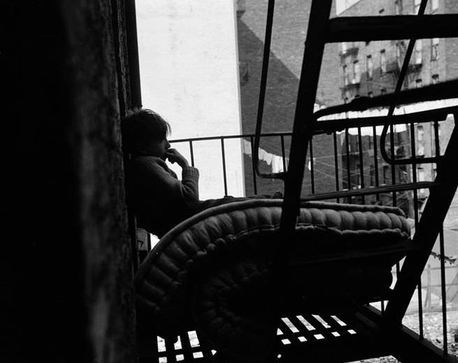 Boy and mattress on a fire escape, 1935.