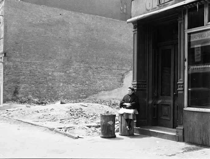 Woman sitting on a garbage can, 1935.