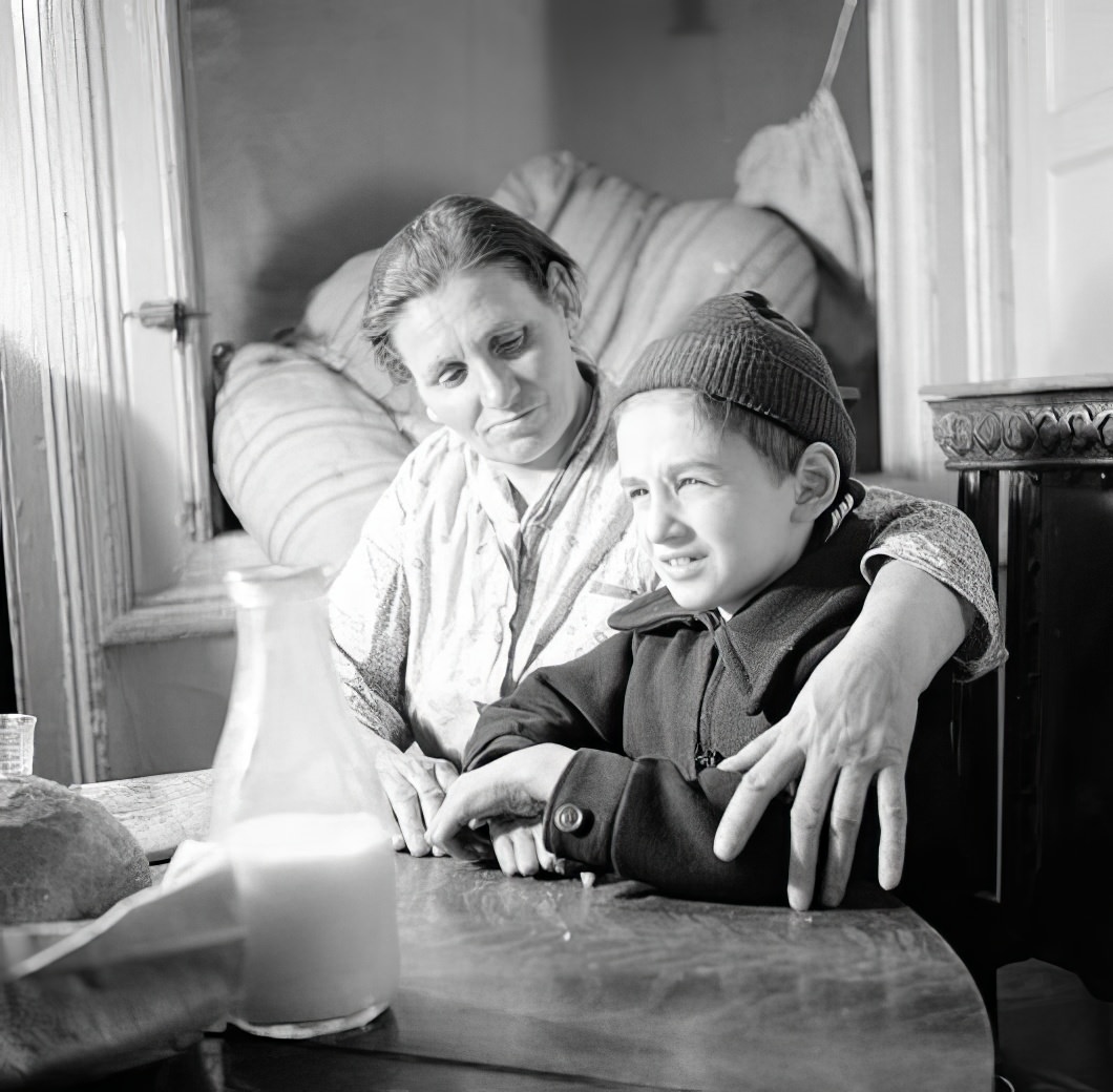 Boy and mother at a table, 1935.