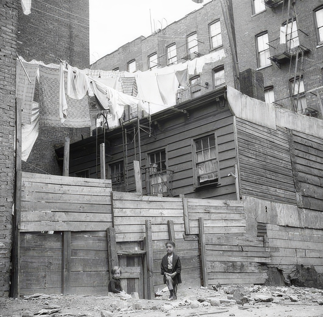 Little girl near rear wooden tenements, 1936