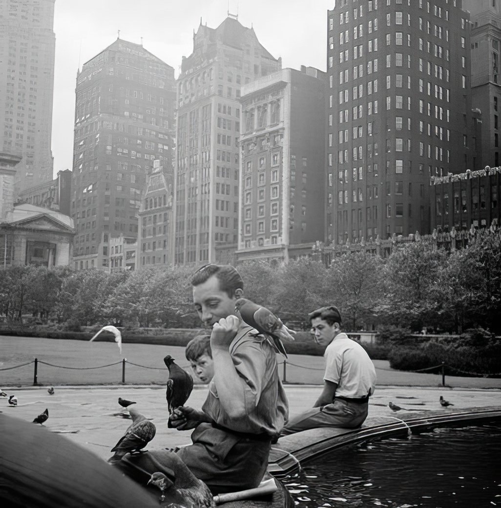 Feeding birds by a fountain in Bryant Park, 1940.