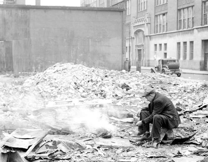 Man cooking in junk lot, 1936