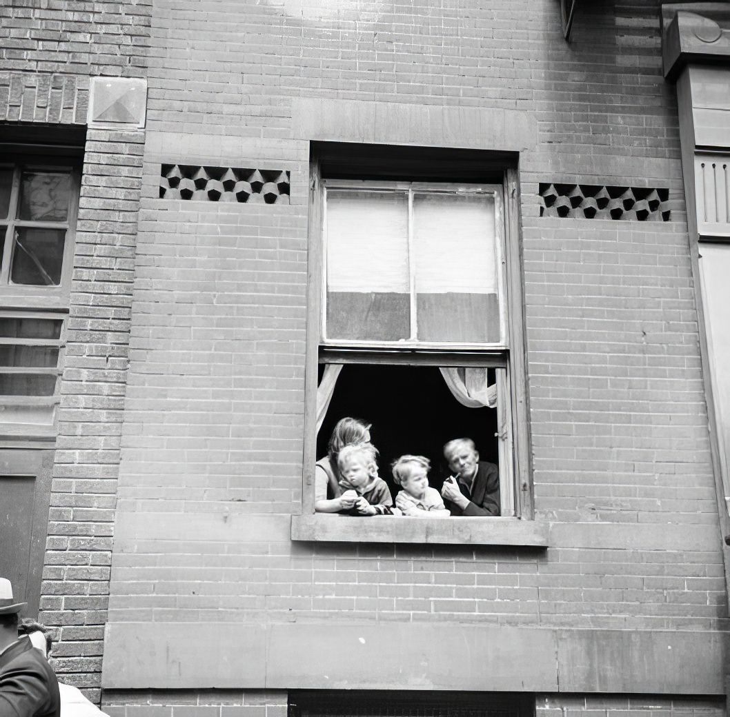 Family looking out of window, 1936