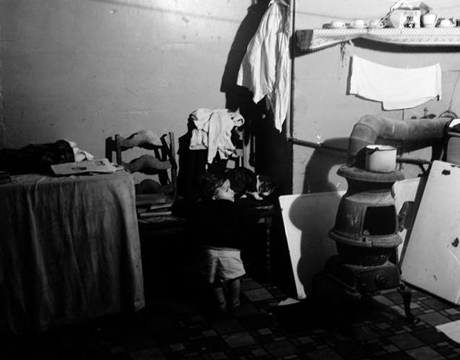 Baby and cat in slum interior, 1935