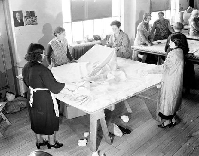 Adding batting to a quilt, 10th Ave., 1938.