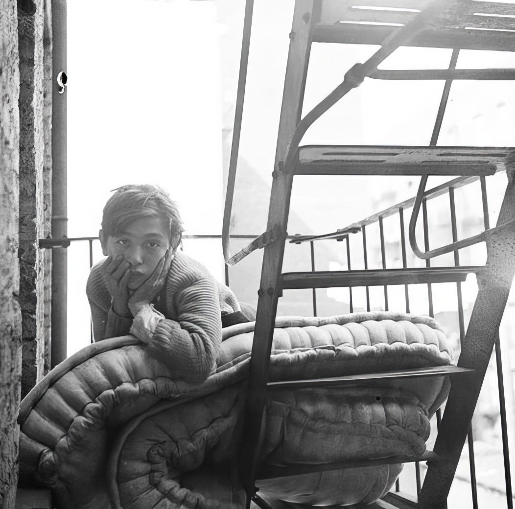 Boy and mattress on a fire escape, 1936.