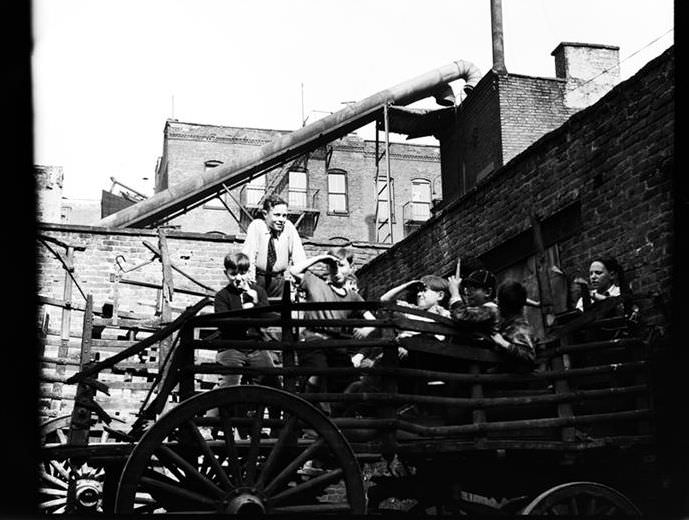 Children playing in a broken wagon, 1936.