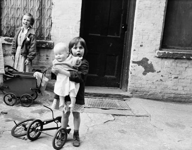 Little girl with doll and tricycle, 1936.