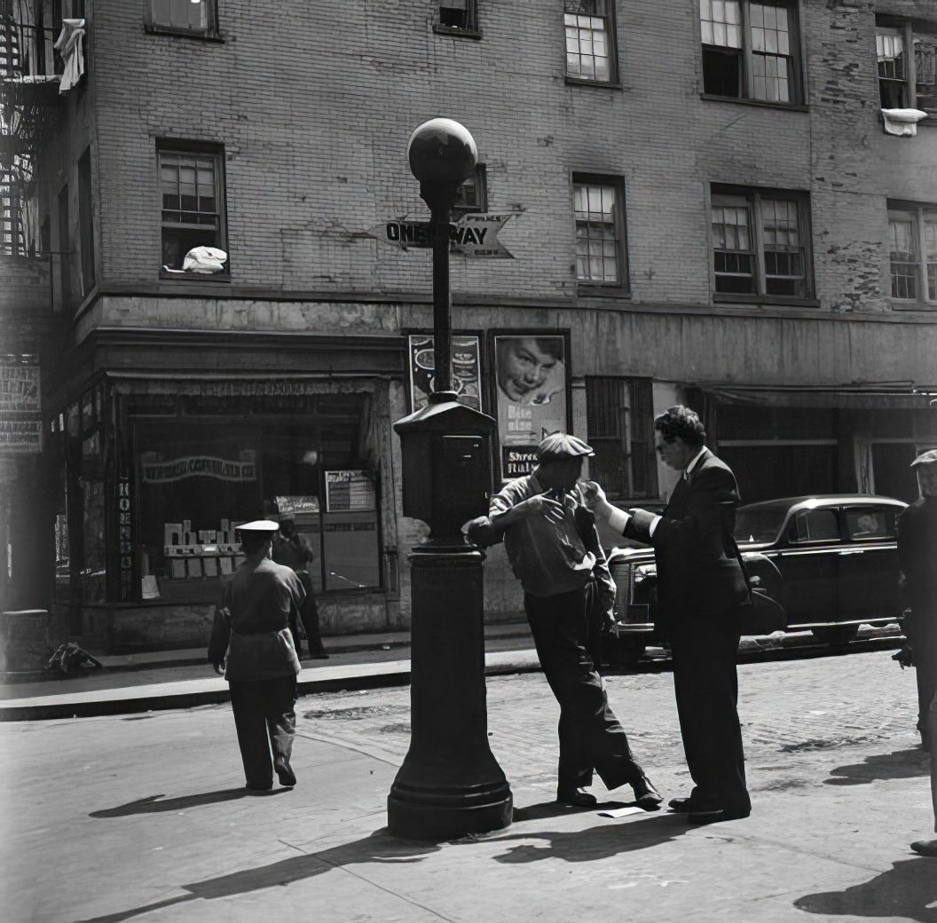 Men lounging near lamp pole, 1935.