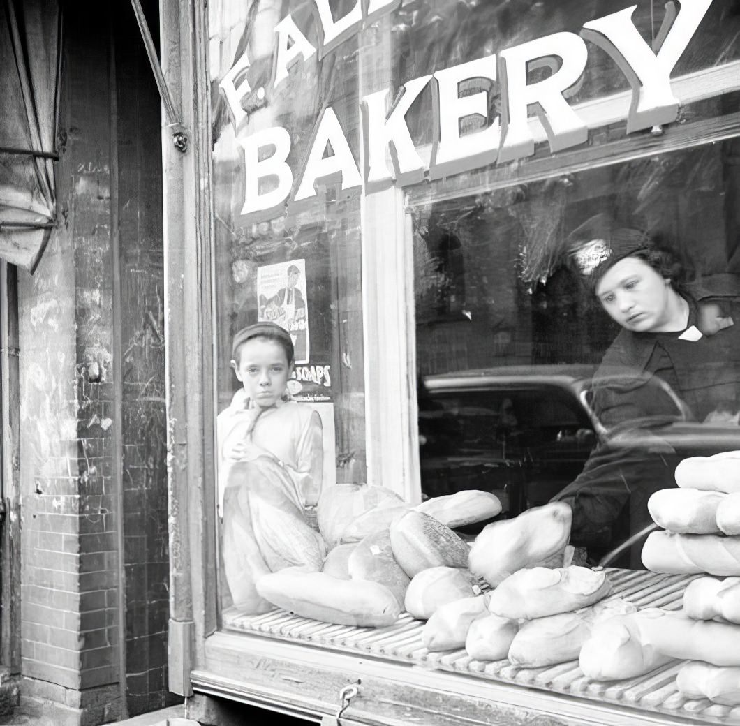 Boy looking in a bakery window, 1935.