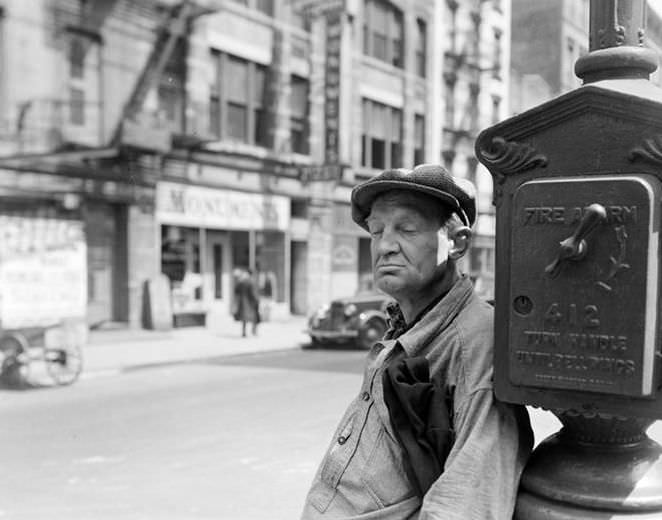 Man leaning on a fire alarm box, 1936.