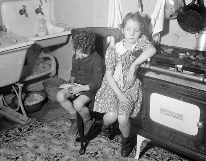 Two children in dreary kitchen, 1936.