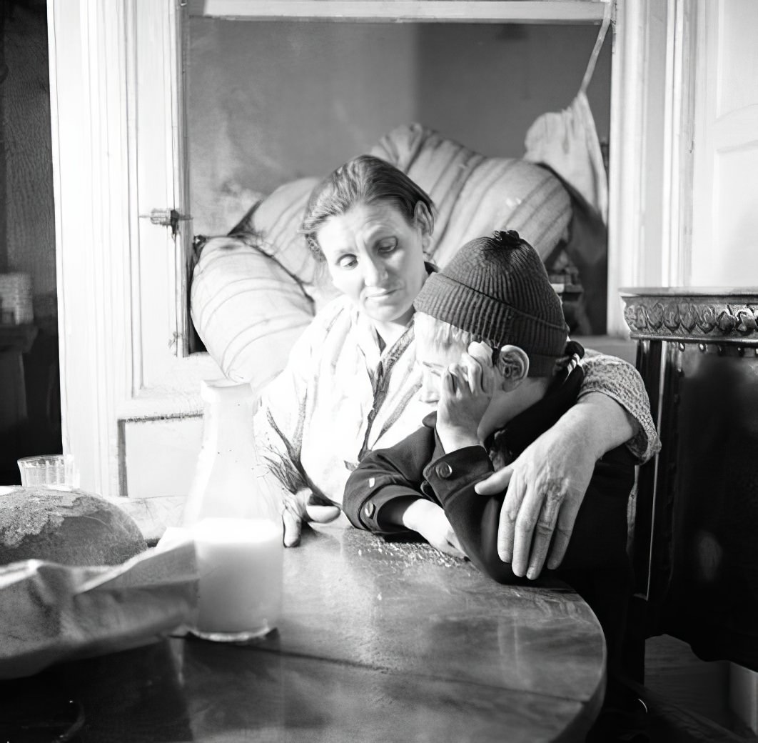 Boy and mother at a table, 1936.