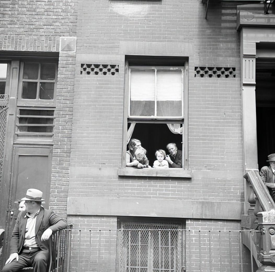 Family looking out of window, 1935.