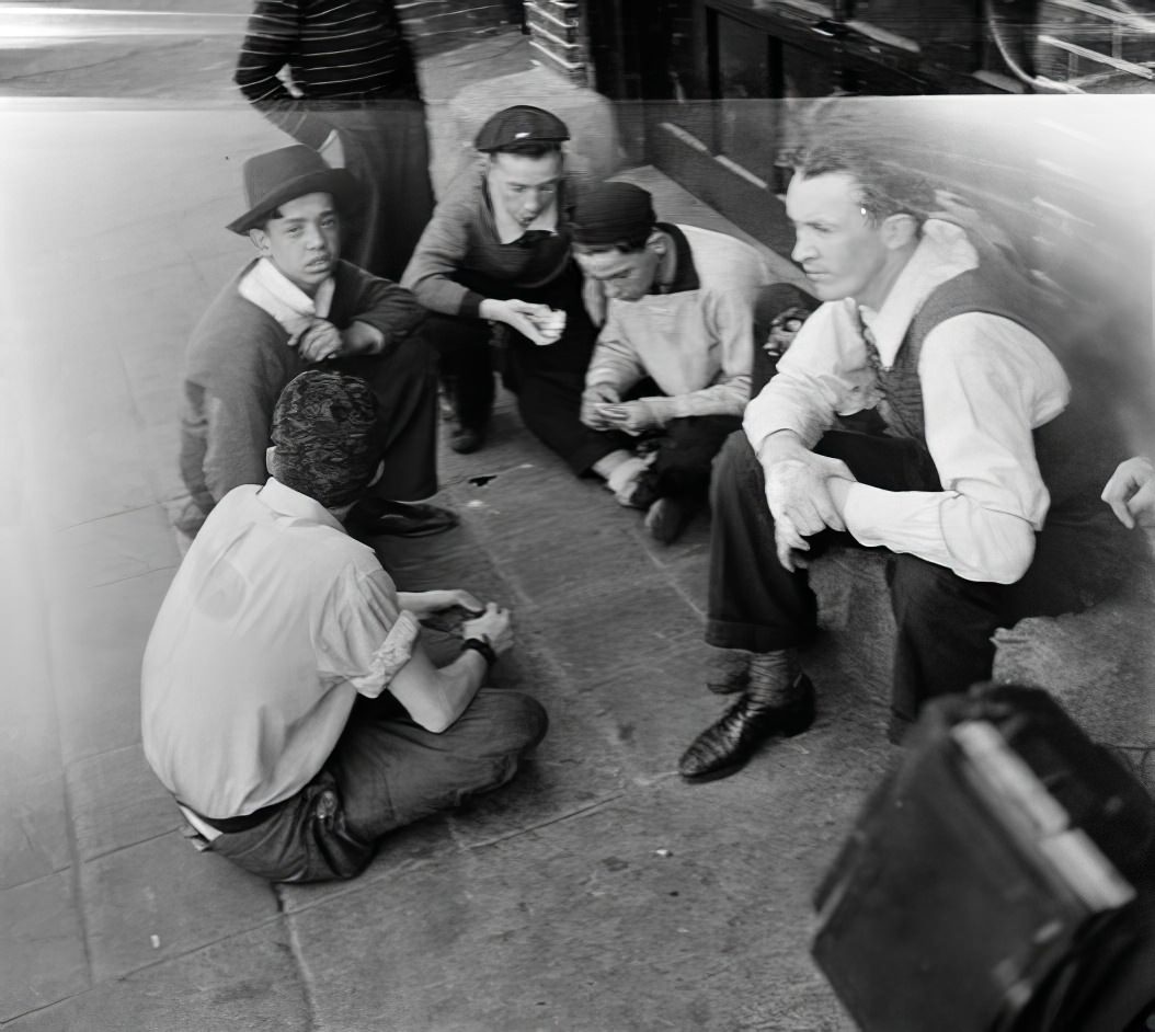 Circle of young men on the sidewalk, 1935.