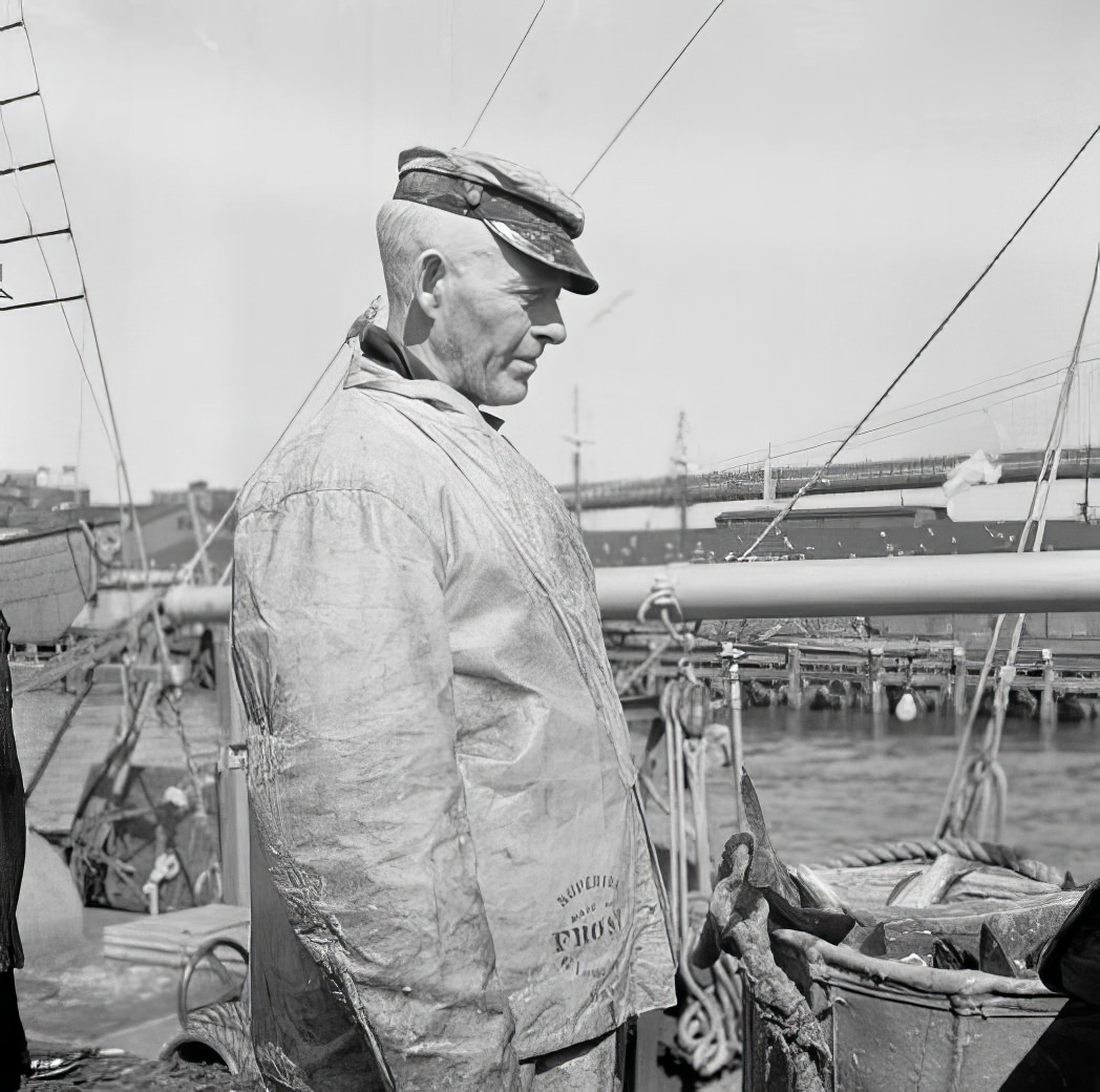 Waterfront scene: man in fisherman's slicker, May 1937.