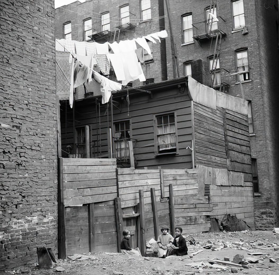 Wooden rear tenements: children playing in dirt, 1936.