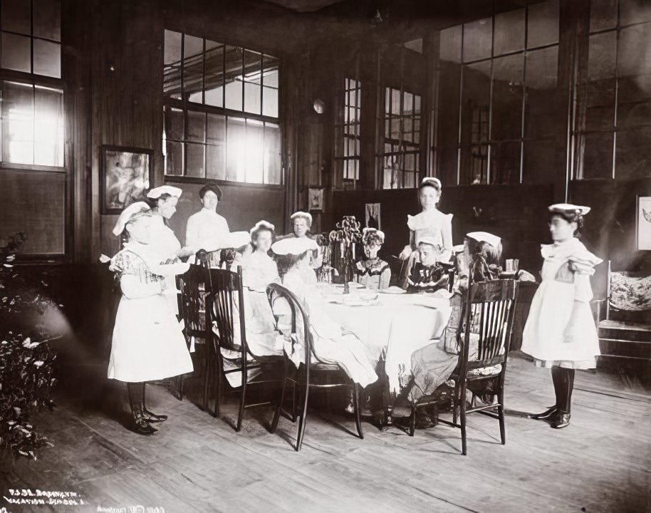 Children waiting at a table in vacation school, 1902.