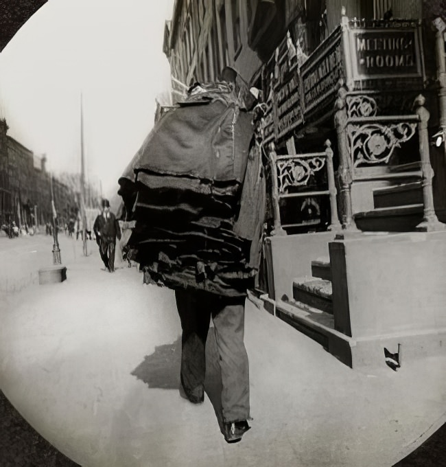 Man carrying bundle of clothes, circa 1895.