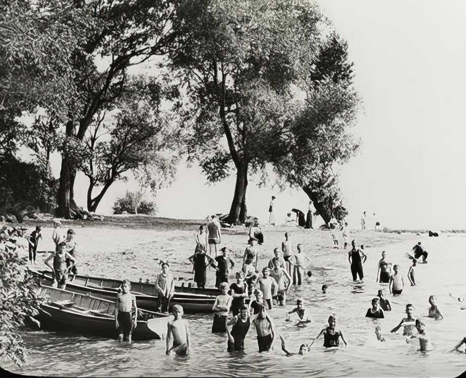 Young children in the water and on the beach, circa 1900.