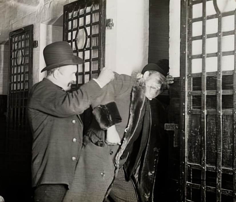 Well-dressed man being thrown into jail, circa 1895.