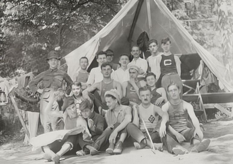 Group portrait in front of tent, circa 1914.