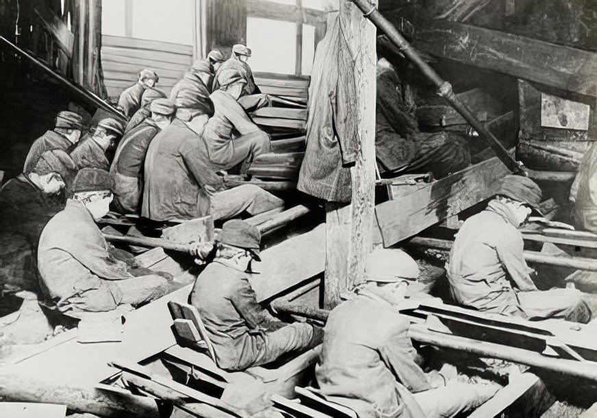 Seated boys under dump, circa 1900.