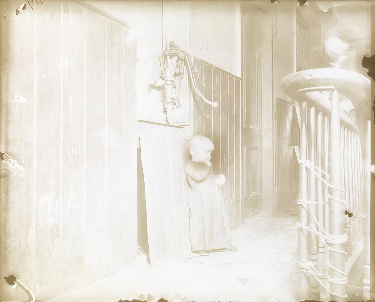 A baby in a dark tenement stairway, 1890s.