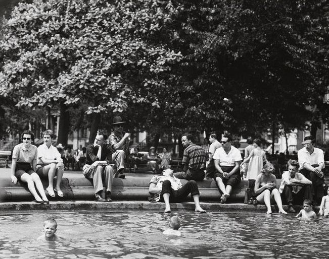 A man sleeping on the fountain steps, three children in the pool, Washington Square Park, 1956.