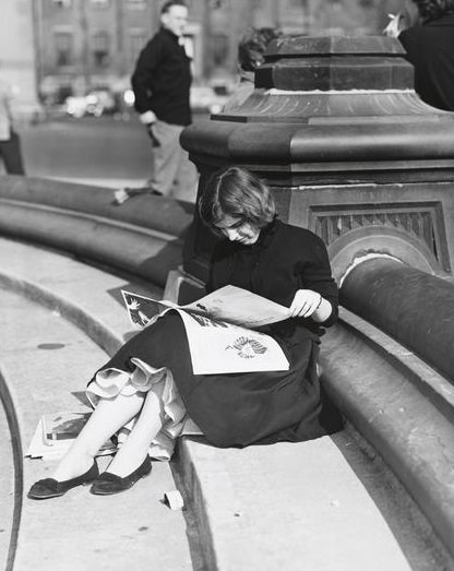 A woman reading the newspaper on the fountain steps, Washington Square Park, 1956.