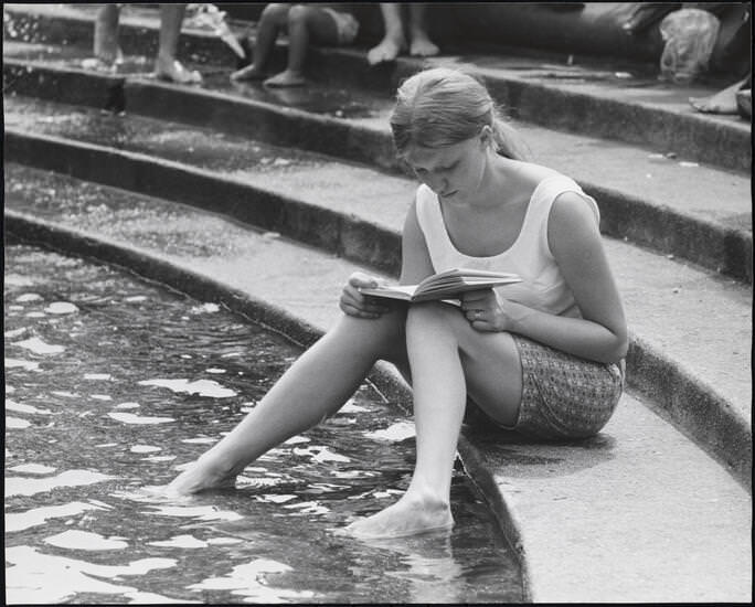 A woman reading on the fountain steps, Washington Square Park, 1955.