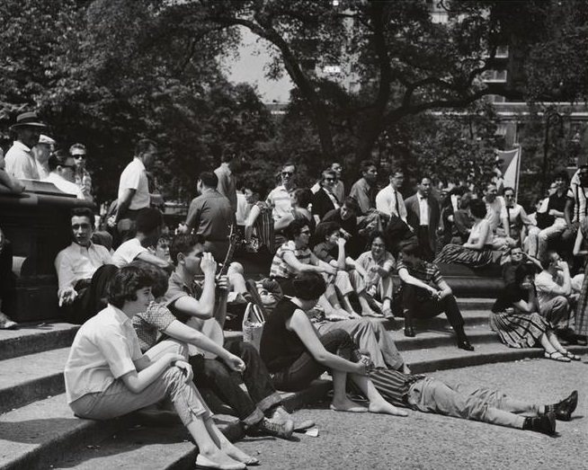 A banjo player in sneakers and jeans on the fountain steps, Washington Square Park, 1956.