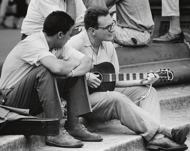 A man watching a guitarist in Washington Square Park, 1956.