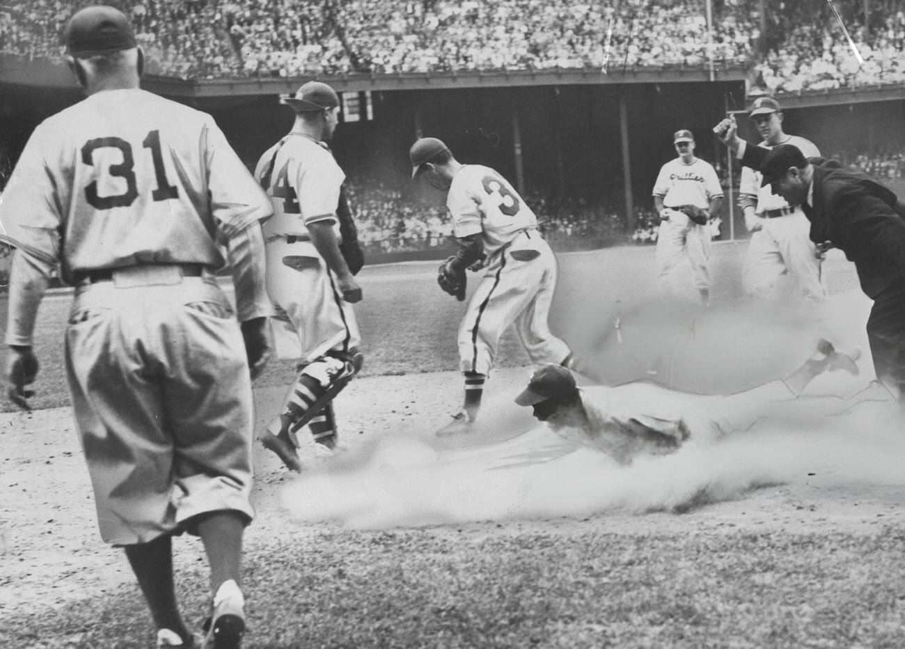 Jackie Robinson in a cloud of dust, 1948.