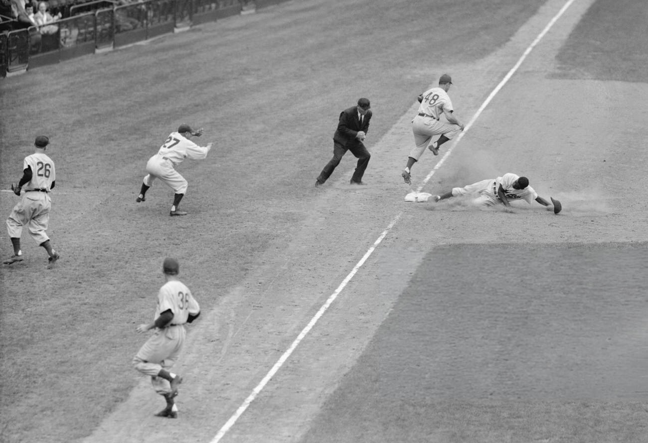 Jackie Robinson sliding into third base, 1940s.