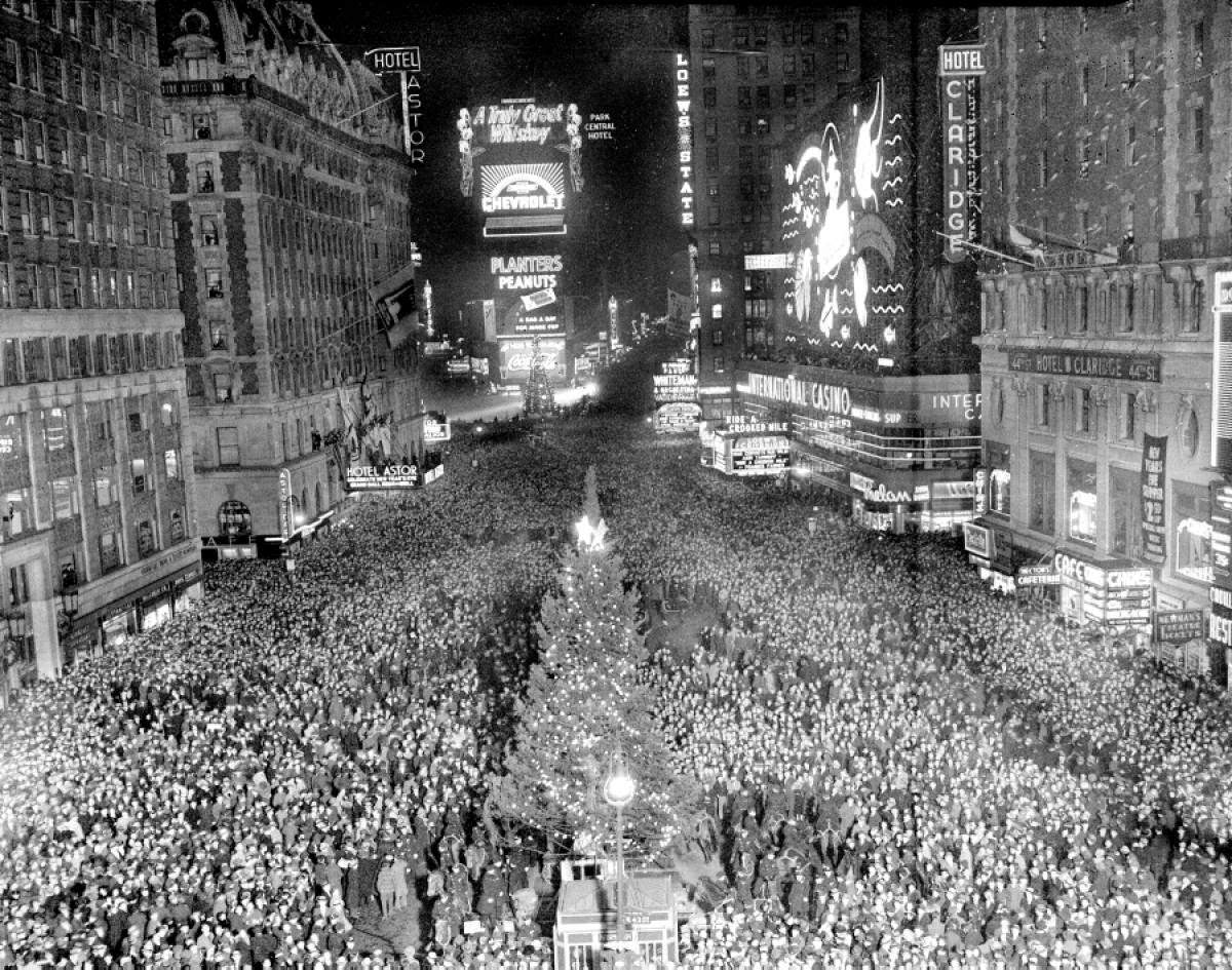 Crowd gathering around a Christmas tree in Times Square, 1938.