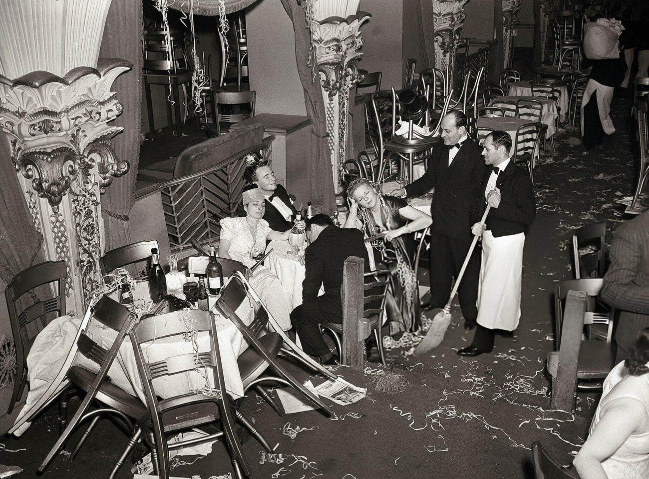 Employees of Billy Rose's Diamond Horseshoe cleaning up after a New Year's Eve party, New York City, 1940.