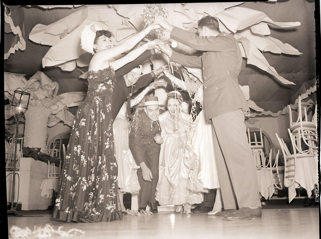 People playing "London Bridge" at a New Year's Eve party, New York City, 1942.