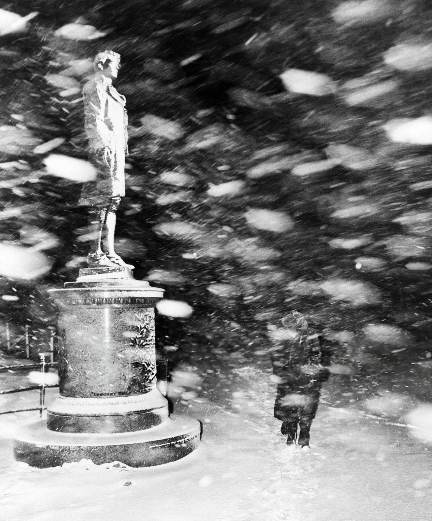 Pedestrian and Nathan Hale statue in the snow in New York, 1947.