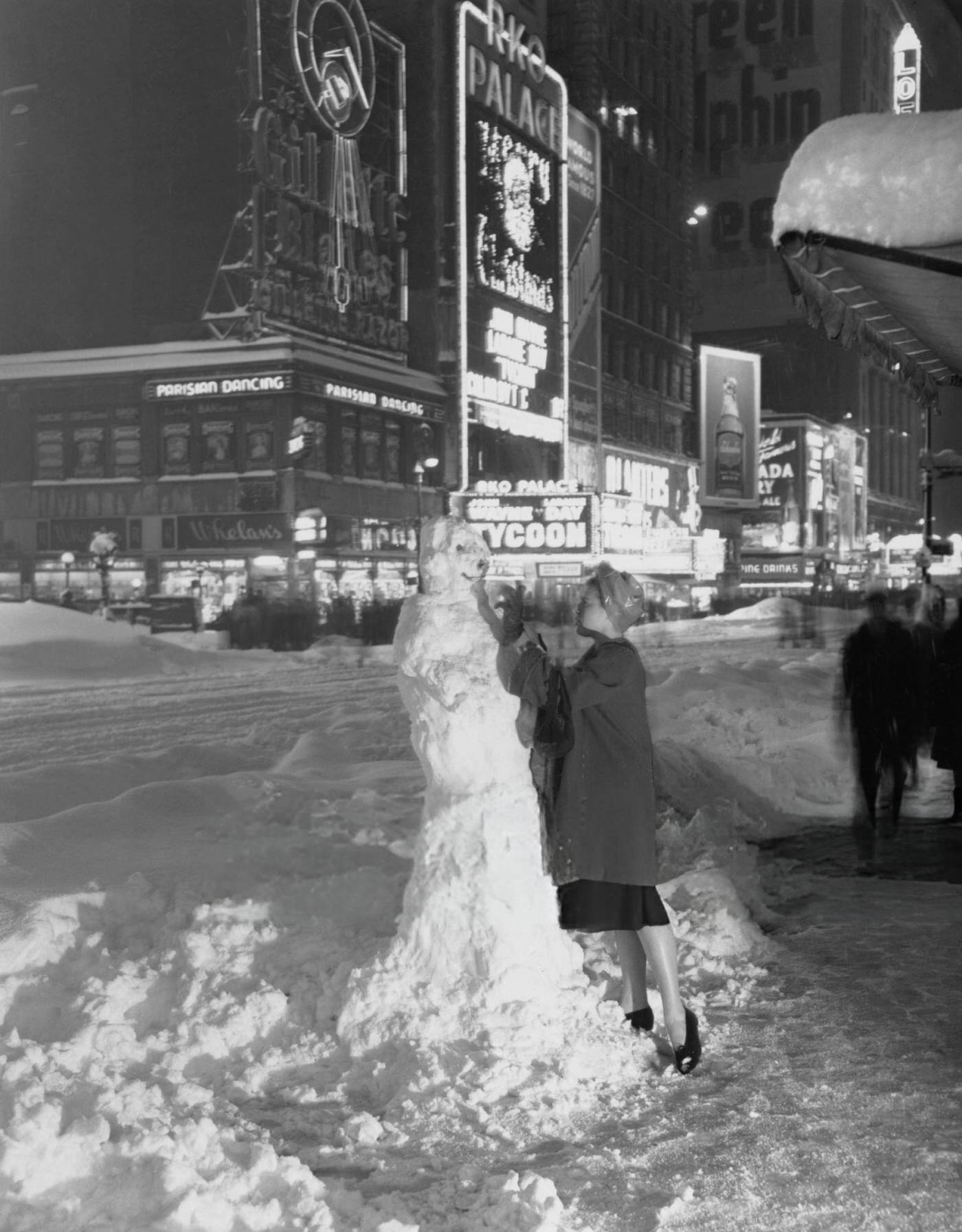 American dancer Bernadette Fischer builds a snowman in Times Square during the Great Blizzard of 1947, New York City, 1947.