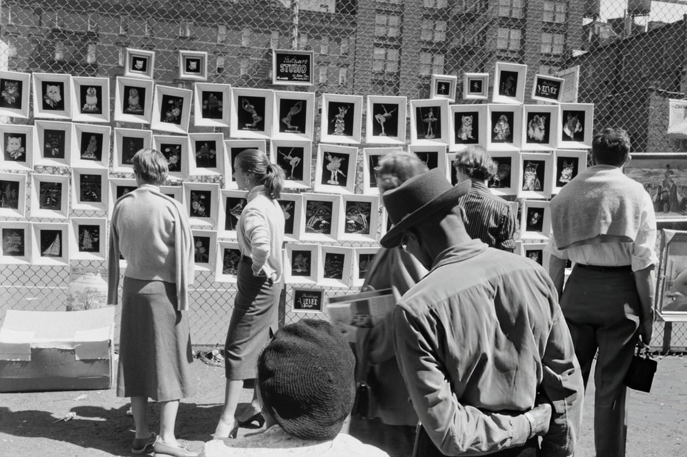 Passersby at a street art exhibition in Greenwich Village, 1954.