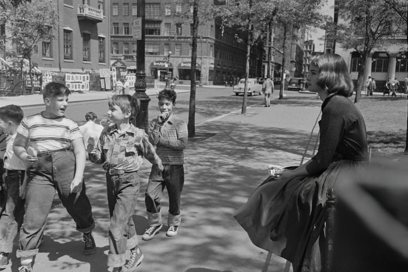 A group of boys passing a young woman in Greenwich Village, 1952.