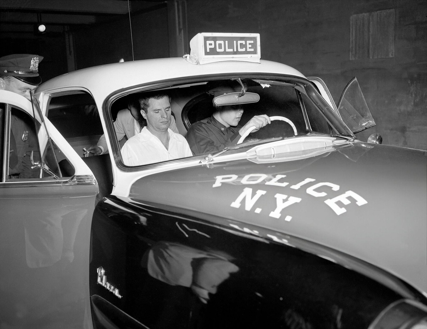 William Daly of Greenwich Village sits glumly in a police car after being ejected from the United Nations gallery.